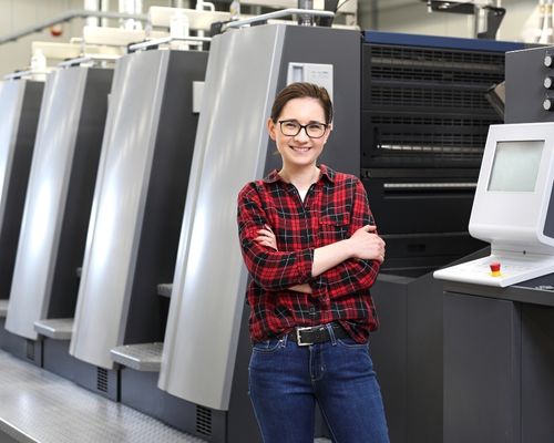 Woman standing in front of an Offset printer.